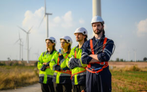 Drużyna inżynierów na tle farmy wiatrowej